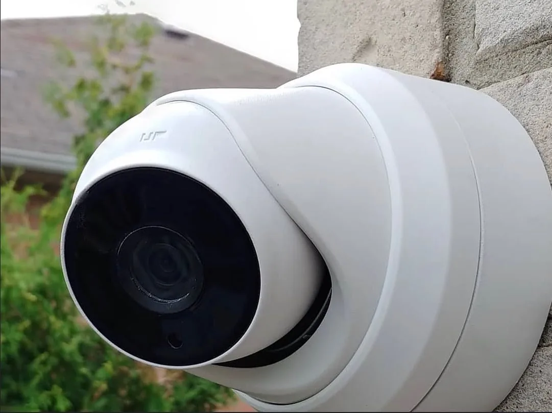 Turret camera on grey brick beside a garden in Mississauga