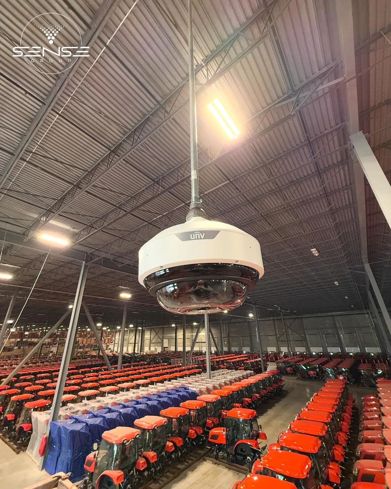 UNV fisheye camera hanging over rows of red tractors in a warehouse