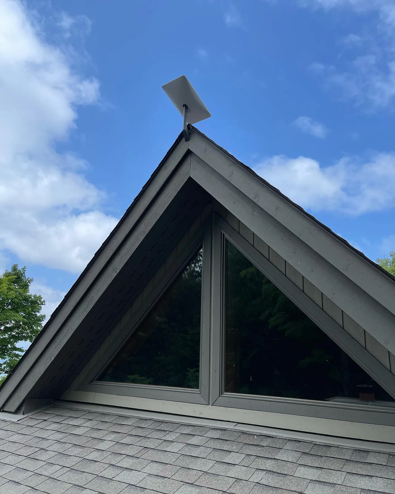 Starlink dish on the peak of an A-frame cottage in Muskoka