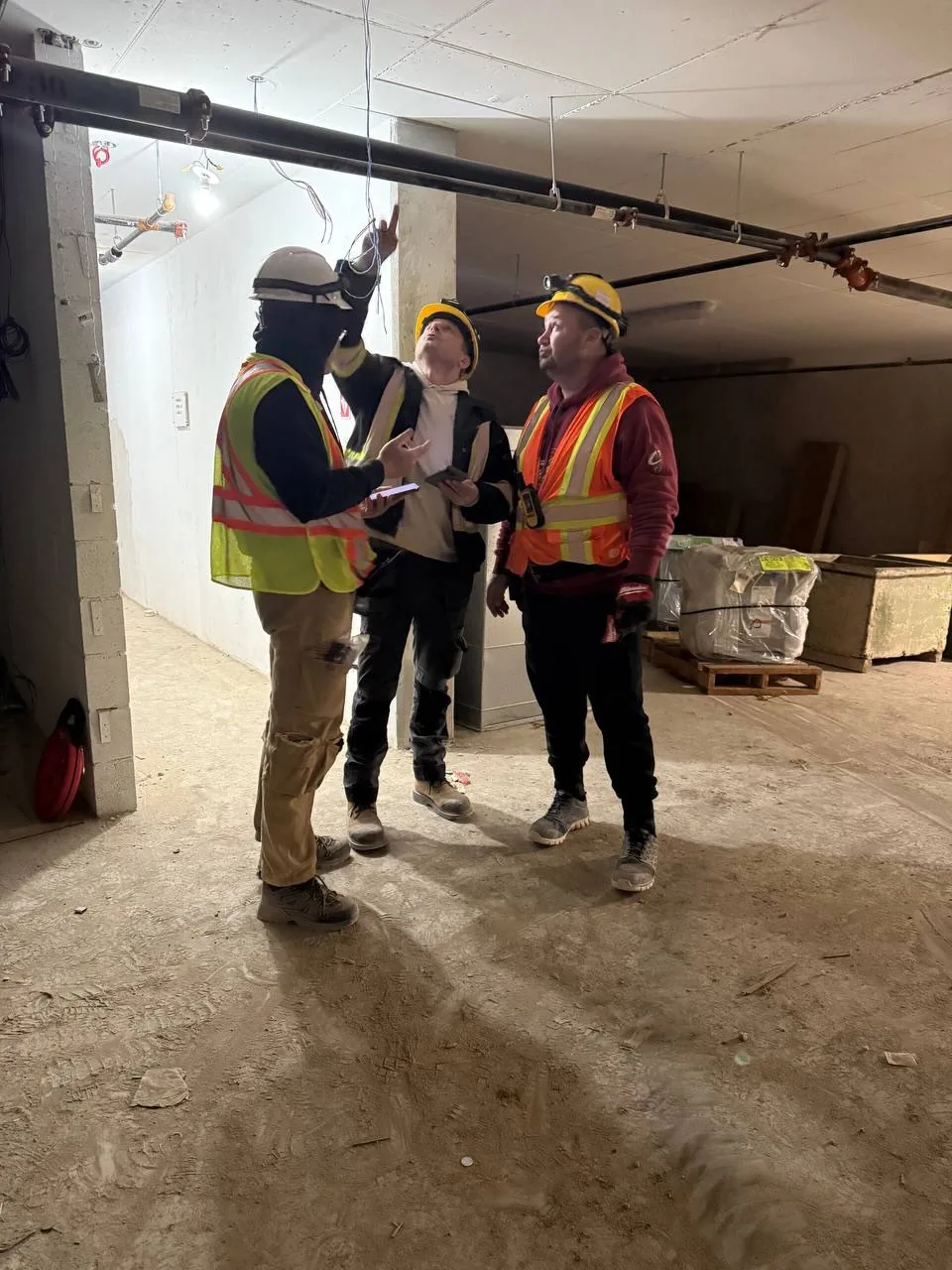 Team walkthrough in an underground parking garage in Toronto with hard hats