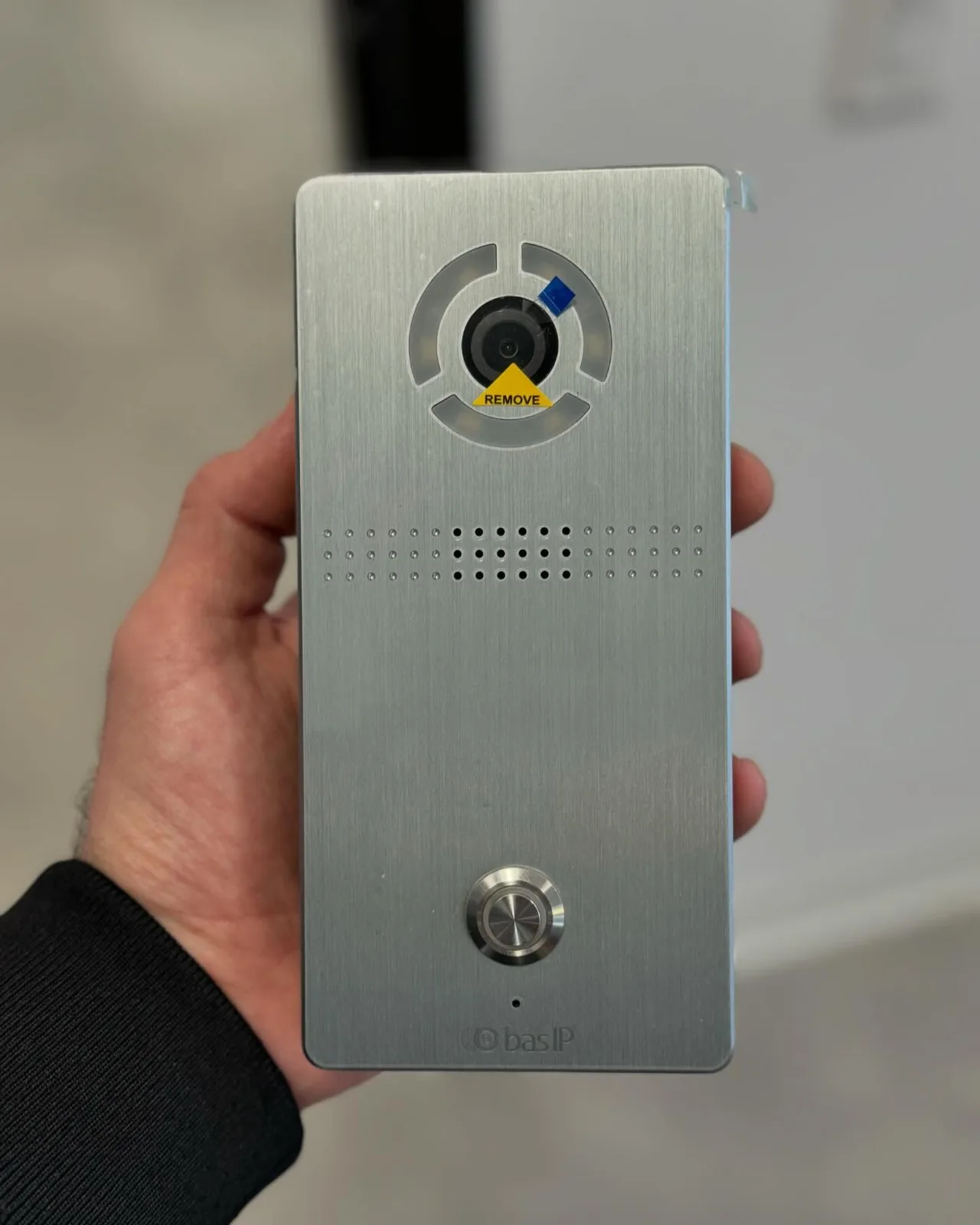 Technician holding a stainless BAS-IP door panel