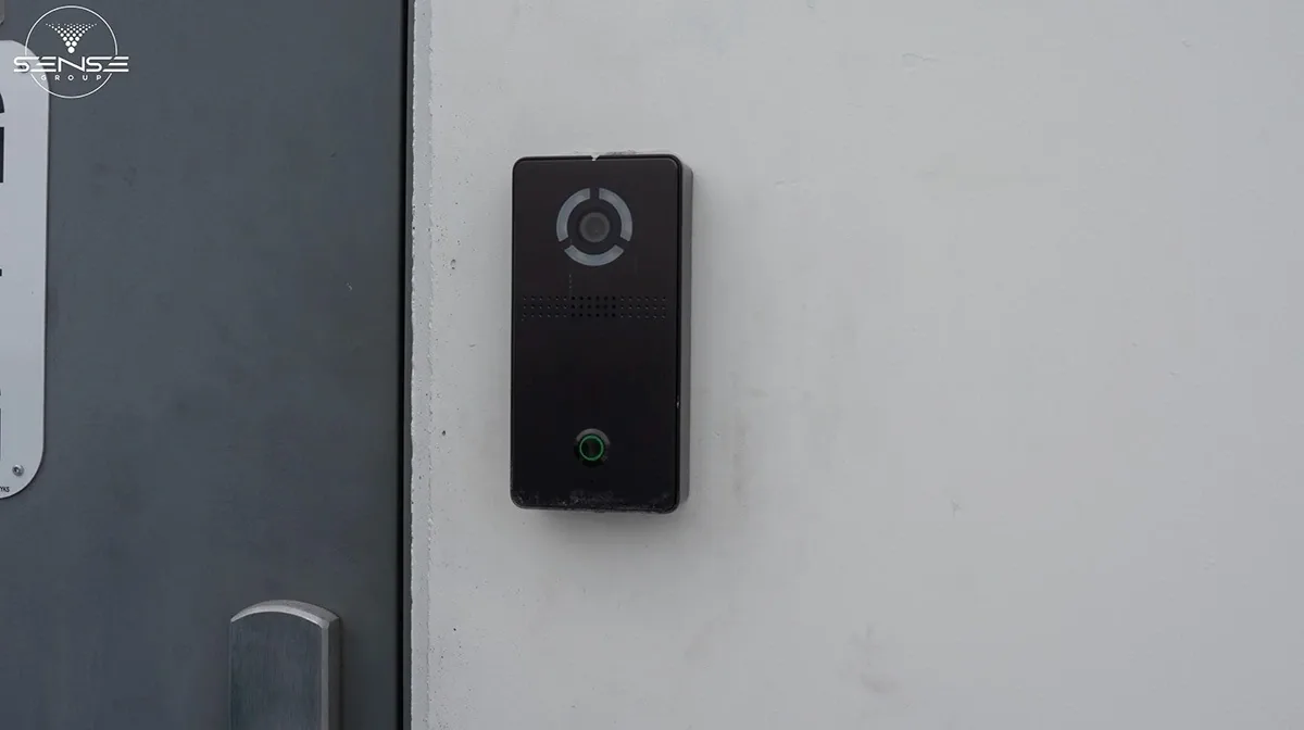 Black video doorbell beside a commercial entrance door