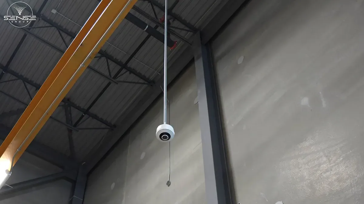 Dome camera near a yellow overhead beam in the warehouse