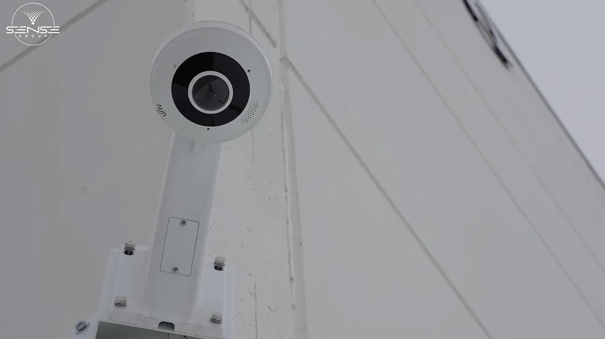 White fisheye camera on an exterior wall bracket