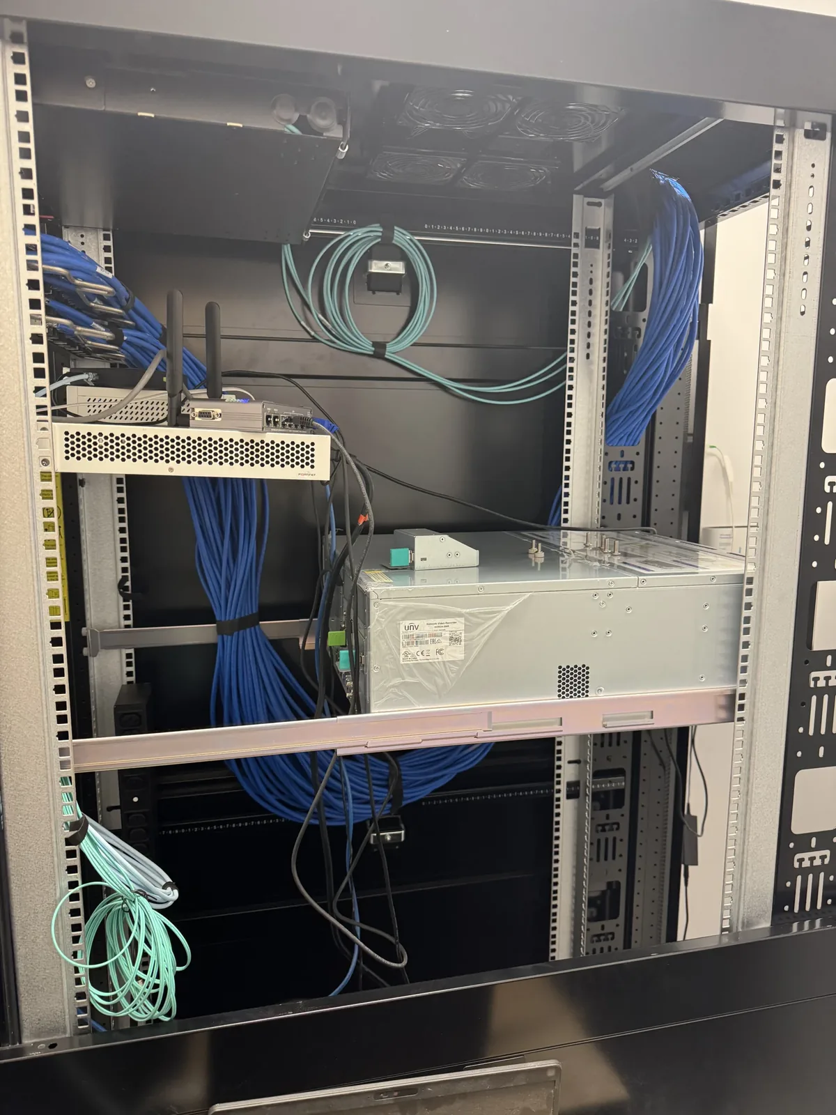 Open network rack with blue cabling, portrait