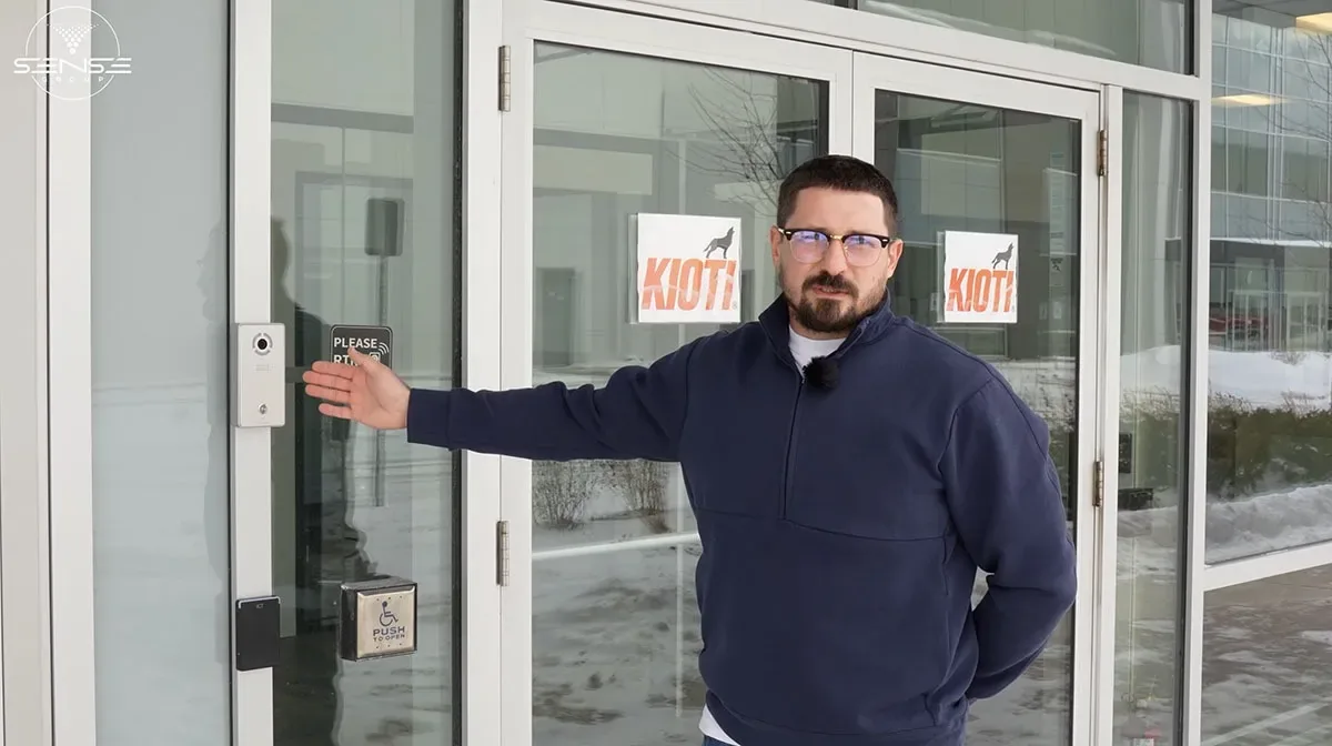 Sense Group technician at the KIOTI warehouse entrance beside the video intercom and access reader