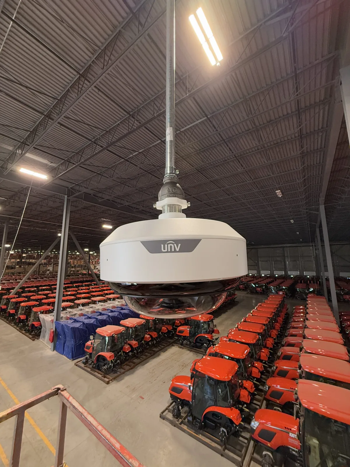 Uniview PTZ camera hanging over rows of red tractors, portrait crop