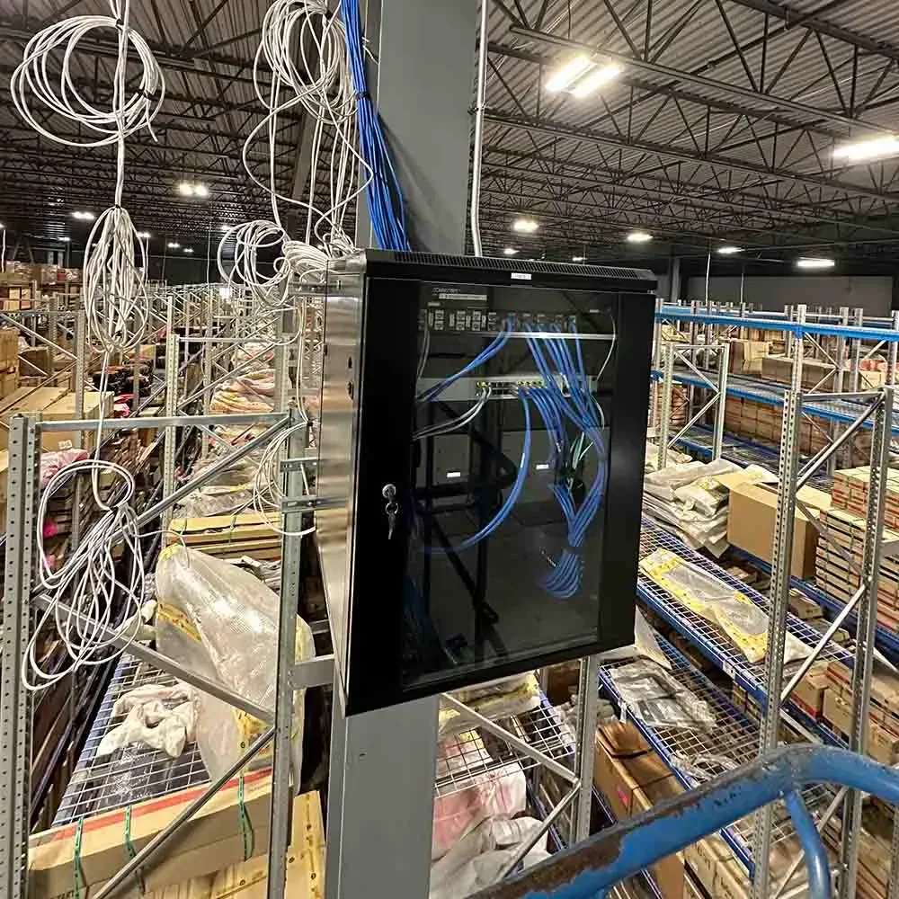 Wall-mounted network cabinet with cabling on a warehouse column