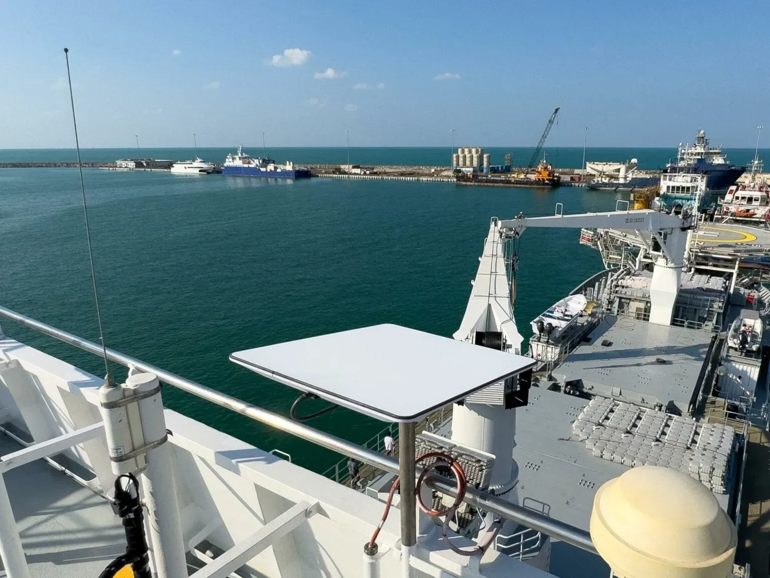 Starlink dish mounted on a ship railing in a port